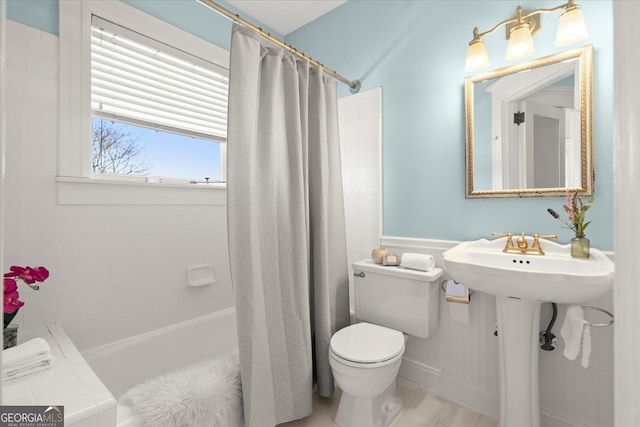 bathroom with tile patterned flooring, a sink, shower / tub combo with curtain, and toilet