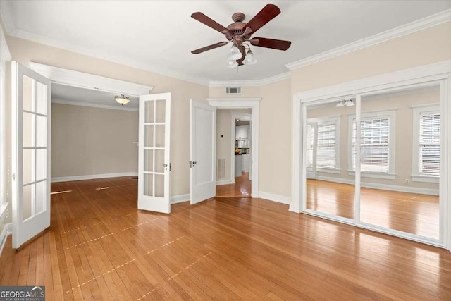 spare room featuring ornamental molding, french doors, visible vents, and wood finished floors