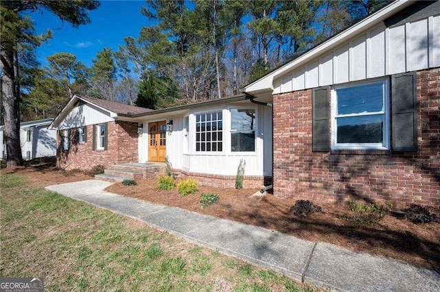 single story home featuring brick siding and board and batten siding