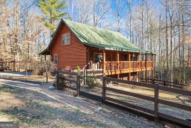 log-style house with metal roof, fence private yard, and log siding