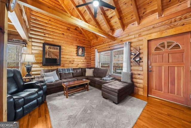 living area with beam ceiling, a ceiling fan, wood ceiling, wood finished floors, and high vaulted ceiling