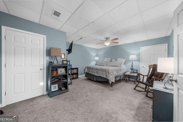 bedroom with visible vents, ceiling fan, a drop ceiling, and carpet flooring