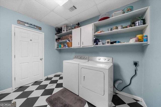 clothes washing area featuring dark floors, visible vents, baseboards, independent washer and dryer, and cabinet space