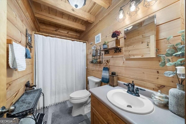 bathroom with a shower with shower curtain, toilet, vanity, wood walls, and beam ceiling