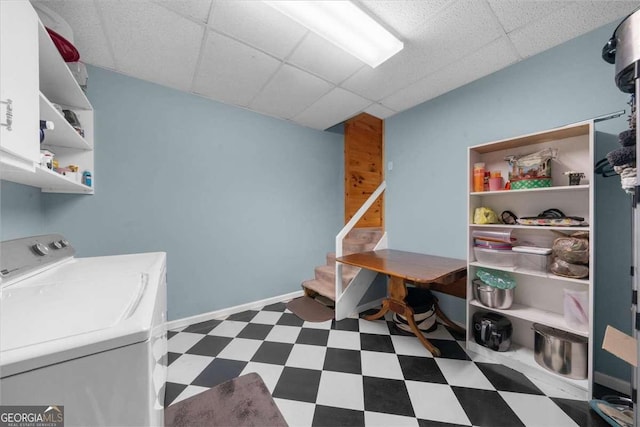 clothes washing area with dark floors, cabinet space, washer and dryer, and baseboards