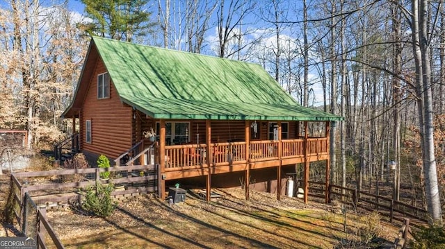 exterior space featuring log siding and metal roof