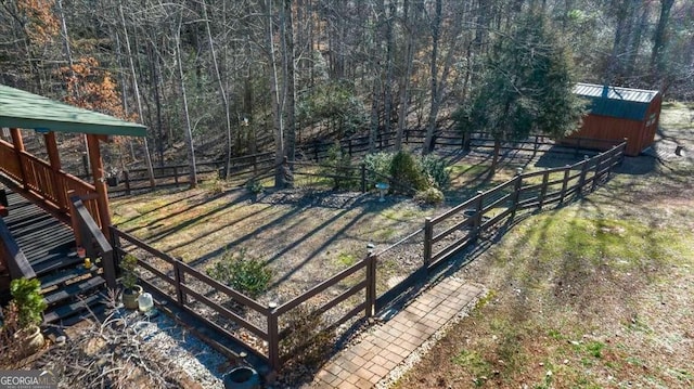 view of yard with a storage shed, fence, and an outbuilding