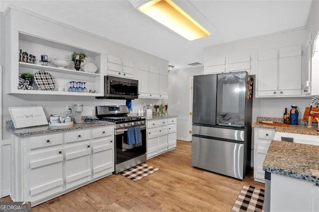 kitchen featuring stainless steel appliances, white cabinets, light wood-type flooring, light stone countertops, and open shelves