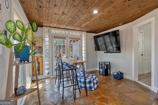 dining space featuring french doors, wooden ceiling, and baseboards