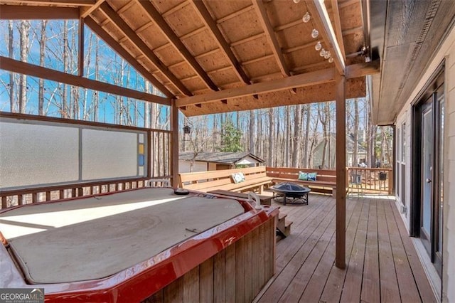 wooden deck with a covered hot tub and an outdoor fire pit