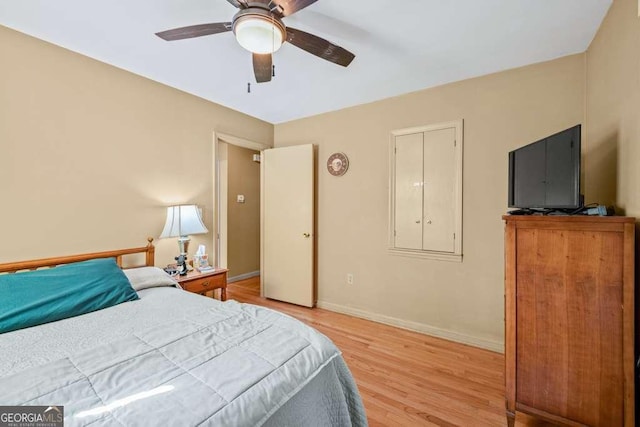 bedroom with light wood-type flooring, ceiling fan, and baseboards