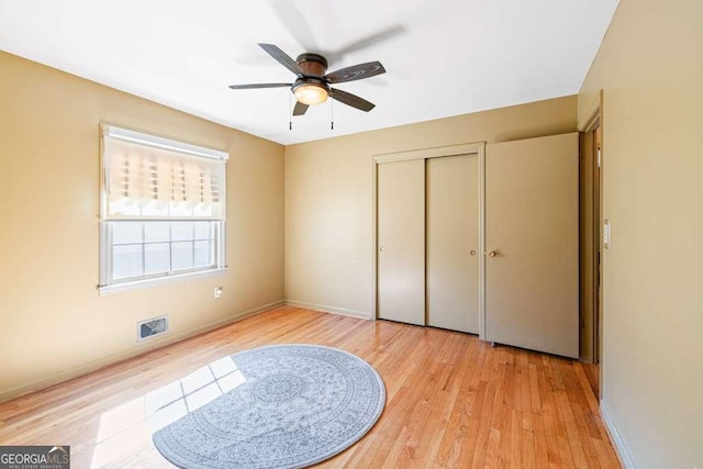 bedroom featuring a closet, light wood-type flooring, visible vents, and baseboards