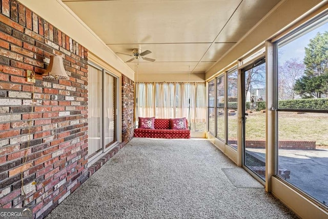 unfurnished sunroom featuring ceiling fan