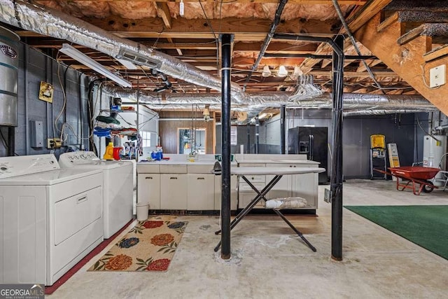 unfinished basement with gas water heater, washing machine and clothes dryer, and black fridge with ice dispenser