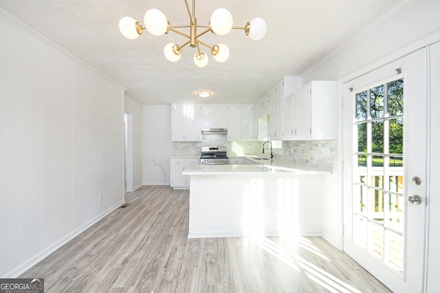 kitchen with a peninsula, electric range, a sink, white cabinets, and light countertops