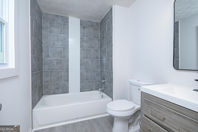 full bath featuring toilet, washtub / shower combination, vanity, a textured ceiling, and wood finished floors