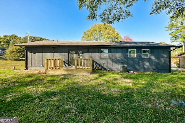 rear view of house with french doors, a lawn, board and batten siding, crawl space, and a deck