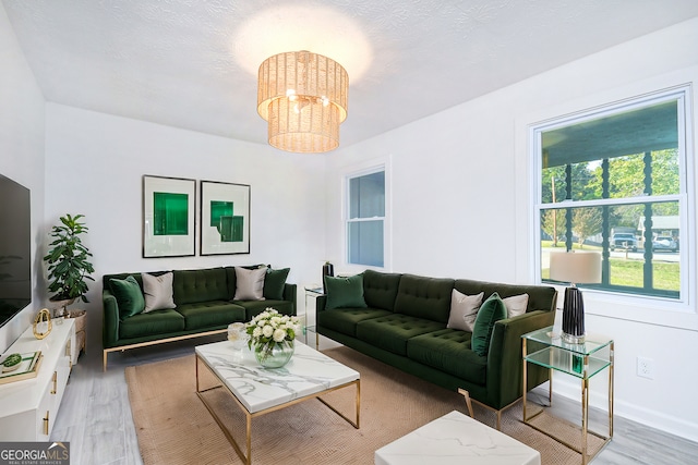 living room with an inviting chandelier and wood finished floors