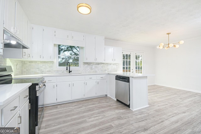 kitchen featuring hanging light fixtures, stainless steel appliances, light countertops, under cabinet range hood, and a sink