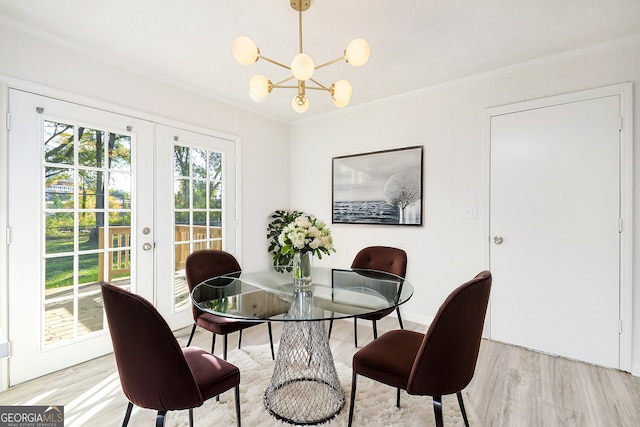 dining area featuring ornamental molding, french doors, light wood-type flooring, and a chandelier