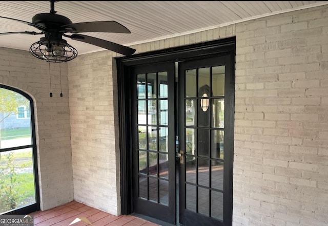 view of exterior entry featuring ceiling fan and french doors