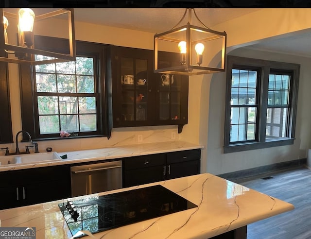 kitchen featuring stainless steel dishwasher, glass insert cabinets, black electric cooktop, and decorative light fixtures