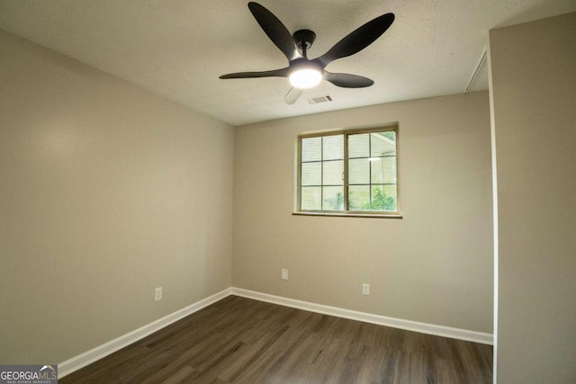 unfurnished room featuring dark wood-type flooring, visible vents, baseboards, and a ceiling fan