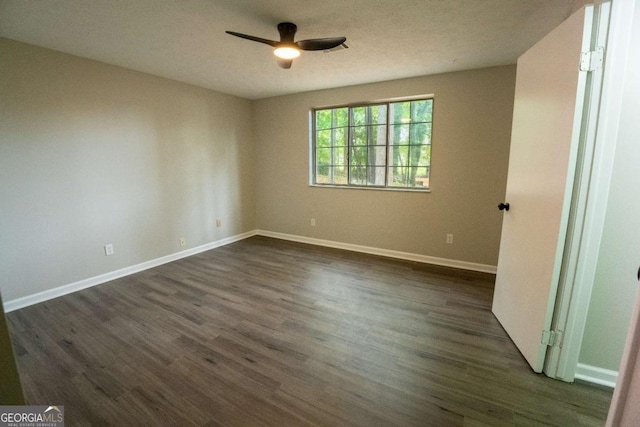 unfurnished bedroom featuring a ceiling fan, dark wood-style flooring, and baseboards