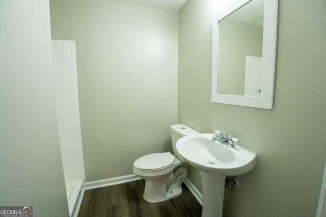 full bathroom with toilet, baseboards, and wood finished floors