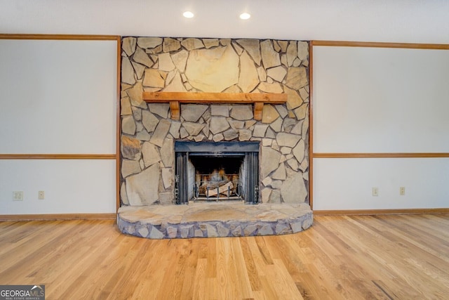 details featuring a stone fireplace, recessed lighting, wood finished floors, and baseboards