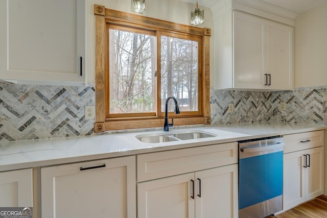 kitchen featuring dishwashing machine, white cabinetry, light countertops, and a sink