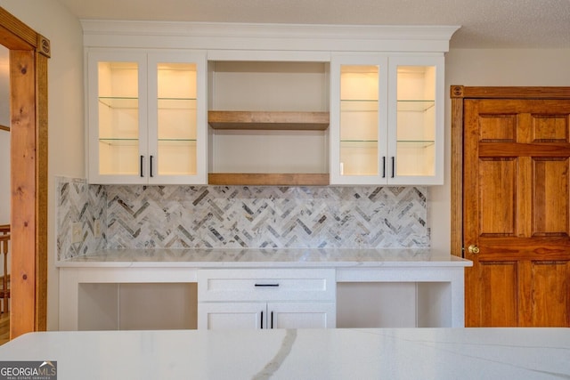 71 Canvasback Ct, Monticello, GA 31064 - kitchen featuring open shelves, decorative backsplash, white cabinets, and glass insert cabinets