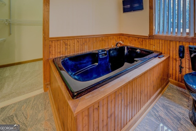 misc room featuring a wainscoted wall, wood walls, and carpet flooring