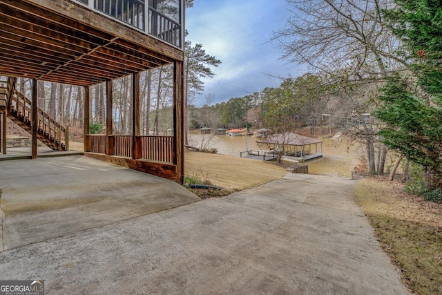 view of yard with stairs, a patio, and a dock