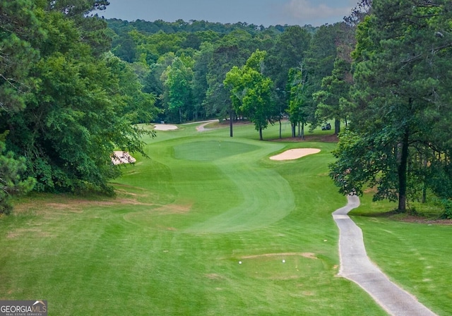 surrounding community featuring golf course view and a yard