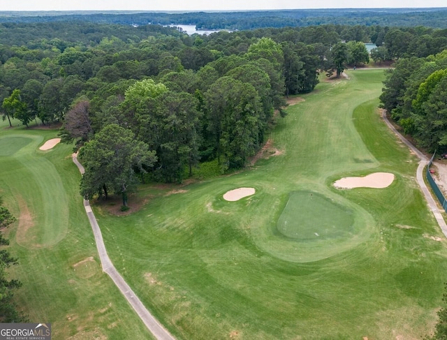 aerial view featuring a forest view and golf course view