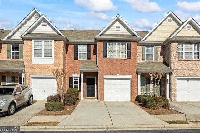 view of property featuring brick siding, driveway, and an attached garage