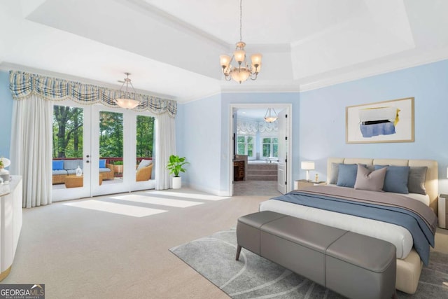 carpeted bedroom featuring a chandelier, access to exterior, ornamental molding, a tray ceiling, and ensuite bath