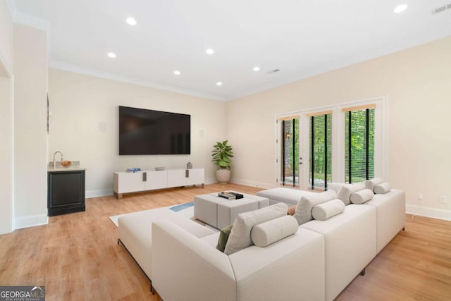 living area with ornamental molding, light wood finished floors, recessed lighting, and baseboards