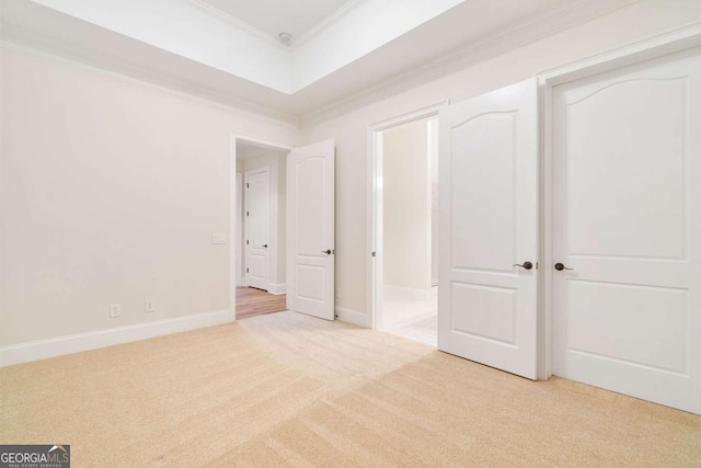 unfurnished bedroom with light carpet, crown molding, and baseboards