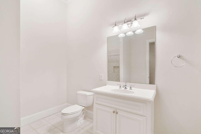 bathroom featuring baseboards, vanity, toilet, and tile patterned floors