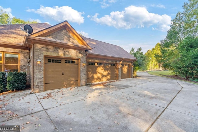 view of front of house featuring a garage, a shingled roof, and concrete driveway