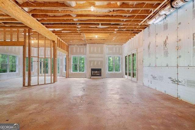 unfurnished living room featuring a fireplace and unfinished concrete floors