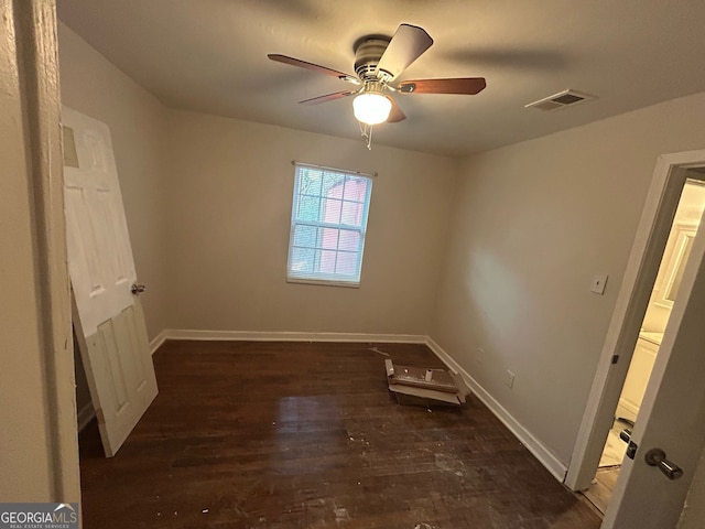 unfurnished bedroom with dark wood-style floors, baseboards, visible vents, and a ceiling fan