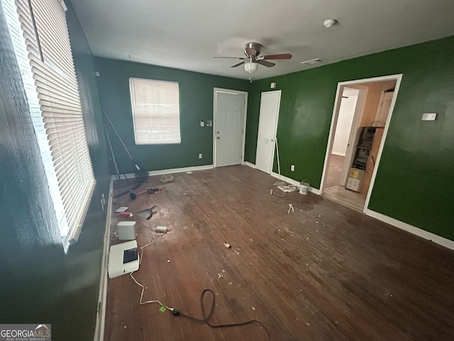 unfurnished bedroom with ceiling fan, dark wood-type flooring, visible vents, and baseboards