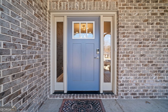 view of exterior entry with brick siding