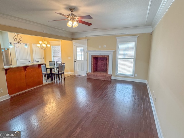 unfurnished living room featuring a brick fireplace, crown molding, baseboards, and dark wood-style flooring