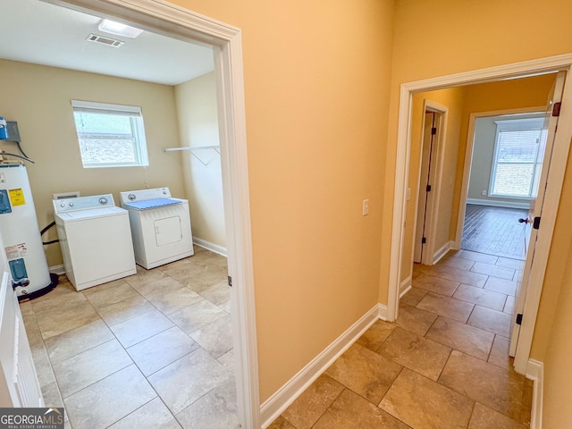 laundry room with water heater, visible vents, laundry area, independent washer and dryer, and baseboards