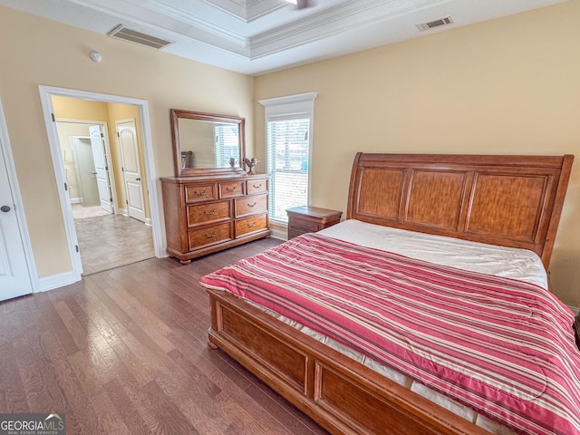 bedroom featuring baseboards, visible vents, dark wood finished floors, and ornamental molding