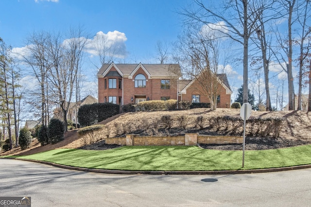 view of front of property featuring brick siding and a front lawn